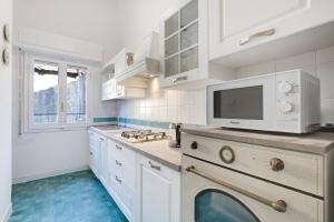 萨沃纳Pratolina的厨房配有白色橱柜和洗碗机。