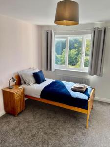 斯丹斯达蒙费雪特Large 5 bed detached house near Stansted Airport的一间卧室设有一张床和一个窗口