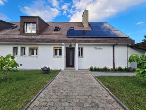 EcublensMilladon Logement en face de l'EPFL的屋顶上设有太阳能电池板的白色房子