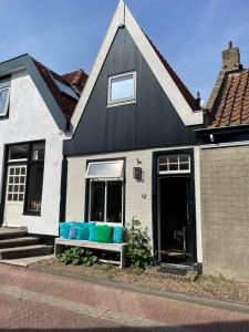 登霍伦Het Heertje的黑白房子,配有带蓝色枕头的长凳