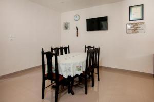 PangururanHotel Wisata Samosir By Helocus的桌子和椅子,墙上挂着一个钟