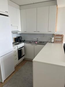 埃斯波Modern and Cozy apartment with Sauna2的厨房配有白色橱柜、水槽和炉灶。