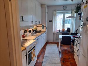 厄斯特松德Karls ställe的厨房配有白色橱柜、桌子和用餐室。
