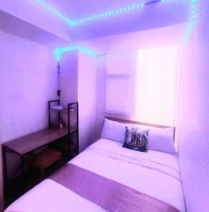 马尼拉2BR in Azure - Beach in the City with WiFi的一间卧室配有一张床和一张带灯光的书桌