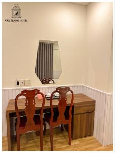 永隆Vân Trang Hotel的梳妆台,配有两把椅子和镜子