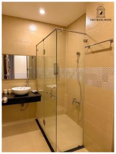 永隆Vân Trang Hotel的一间带玻璃淋浴和水槽的浴室