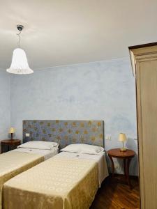 Villa MinozzoLe Boccede Country House B&B的一间卧室设有两张床和蓝色的墙壁