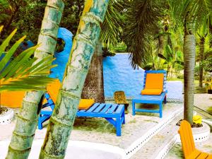 Lance aux ÉpinesReef View Pavilions - Villas & Condos的海滩上的一组椅子和棕榈树