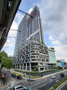 吉隆坡TRION KL by JRLodge Homestay的城市街道上一座高大的建筑,有汽车