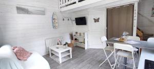 普卢伊内克Chalet cosy, plages à pieds. Morbihan.的一间带桌子的客厅和一间餐厅