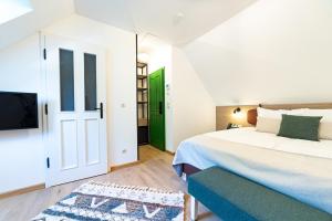 布达佩斯Czakó Bed&Breakfast的卧室配有白色的床和绿门