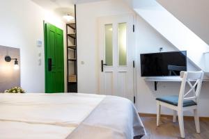 布达佩斯Czakó Bed&Breakfast的一间卧室配有一张床、一张桌子和一扇绿门