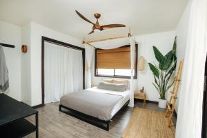 科纳The Bamboo House的一间卧室配有一张床和吊扇