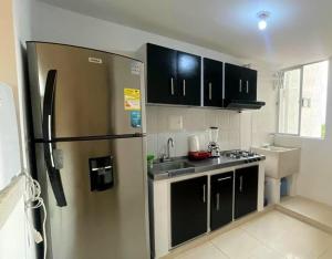 内瓦ST Apto lindo y comodo的厨房配有不锈钢冰箱和黑色橱柜