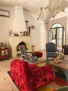 托泽尔Dar Aron Tozeur的客厅设有红色的沙发和壁炉