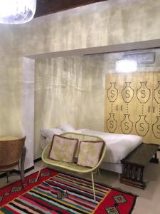 托泽尔Dar Aron Tozeur的一间卧室配有一张床、一张桌子和两个枕头