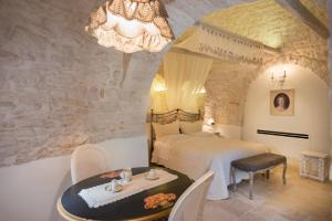 阿尔贝罗贝洛浪漫特鲁利酒店的一间卧室配有两张床、一张桌子和一个吊灯。