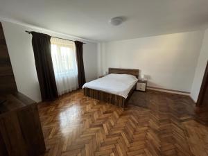 Petreştii de JosCasa Cheilor的一间卧室配有一张床,铺有木地板