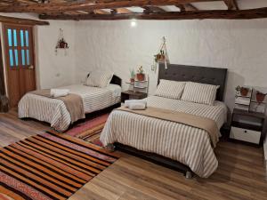 库斯科KOSKO Casa Hotel的一间带两张床的卧室和地毯