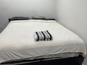 温尼伯The Home Sweet Home的一张白色的床,上面有条纹枕头