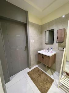 利雅德شقة بموقع مميز的浴室设有门、水槽和镜子