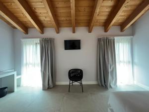 拉齐塞Agriturismo La Rondinella的一间卧室配有一张床、一把椅子和窗户。