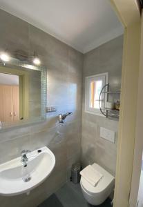 Báscara莱斯罗克斯酒店的一间带水槽、卫生间和镜子的浴室