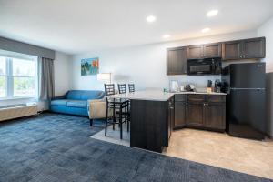霍顿Independence Stay Hotel and Long term suites的厨房以及带冰箱和沙发的客厅。