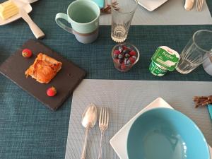 索米尔La douceur Saumuroise avec petit déjeuner的一张桌子,上面放着一盘食物和一碗浆果