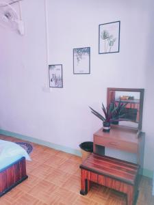 琅勃拉邦天堂鸟花园客栈的一间卧室配有一张床、一张桌子和一面镜子