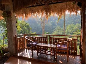TampaksiringBali Inang Jungle View的阳台的门廊配有桌椅