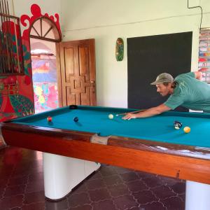 科潘玛雅遗址Stella Hostel Copán的男人在带台球桌的房间里打台球
