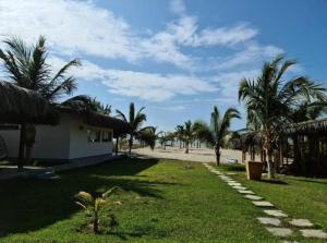 Cruz de PizarroAquamare Bungalows的一条通往棕榈树海滩和一座建筑的道路