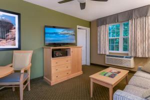 巴港阿卡迪亚旅馆的客厅配有平面电视和桌子。