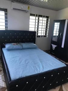 OshienHolly House的一间卧室配有一张蓝色床罩的床