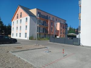 什切青AJP Apartament Szczecin Dąbie的大型建筑前的停车场