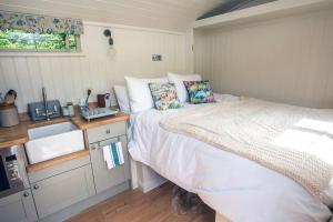 阿伦德尔Shepherds Huts Tansy & Ethel in rural Sussex的一间带床和水槽的小卧室