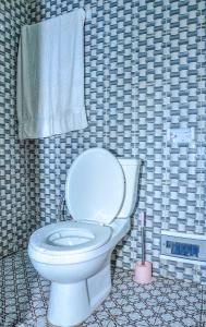 雅温得LES LOGIS DE NOUVELLE ROUTE BASTOS的浴室设有白色卫生间,位于瓷砖墙壁上