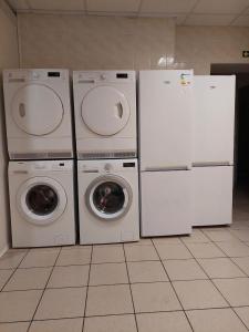 帕兰加Pigus apgyvendinimas Palangoje的房间里的三台洗衣机和两台冰箱