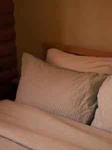 瓦尔达维德Kilomètre 42的一张带白色床单和枕头的床