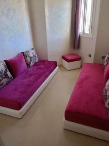 弗尼迪克soleil d'chamalo的客厅配有紫色沙发和2张凳子