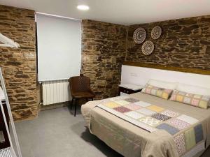 TouroCasa Fontes Rosas的一间卧室设有一张床和石墙