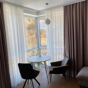 索洛钦Апарт-СЕРВiC жк Сонячний квартал的客房设有桌椅和大窗户。