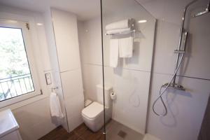 桑亨霍因芬尼特桑克森克索酒店的一间带卫生间和玻璃淋浴间的浴室