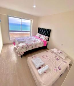 利马Tú hogar frente al mar的背景海洋的客房内的两张床