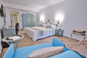康特港埃尔法鲁酒店及水疗中心 的一间卧室配有一张床和一张蓝色的沙发