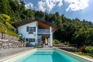 莱泽诺Villa Rosch的房屋前有游泳池的房子