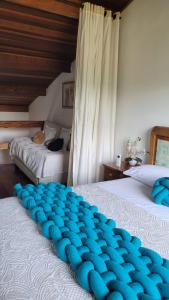 朱奎Apto Duplex com Mezanino的一间卧室配有两张带蓝色枕头的床。