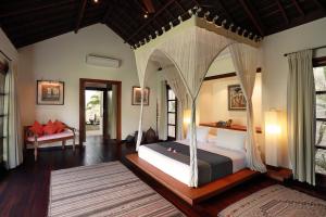 塞米亚克巴厘阿斯里别墅酒店的一间卧室,卧室内配有一张天蓬床