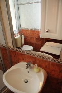 希欧福克Apartman Bella Hotel的一间带水槽、镜子和卫生间的浴室
